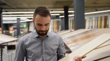 Döşeme mağazasında katları kaplamayı seçen bir adam.