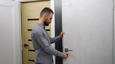 Mağazanın ön kapılarını seçen bir adam.