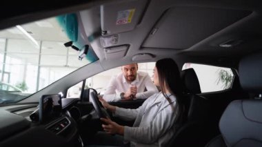 Araba satıcısı yeni arabanın anahtarını genç ve çekici kadına veriyor. Şimdi rüyası gerçek oldu. Genç bir kadın yeni arabasının anahtarlarını alıyor.