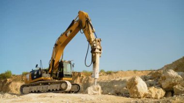 Sarı sondaj makinesi bir taş ocağında sondaj çalışması yapıyor. Madende çalışan sondaj traktörü. Maden ocağı, mayın. Ağır madencilik endüstrisi için ekipman. Taşın çıkarılması