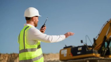 Foreman, maden ocağında telsiz kullanarak sondaj makinesinde çalışanlara emir veriyor. Endüstriyel işçi mühendisi taş ocağında telsiz telsizi kullanıyor.