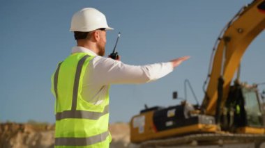 Foreman, maden ocağında telsiz kullanarak sondaj makinesinde çalışanlara emir veriyor. Endüstriyel işçi mühendisi taş ocağında telsiz telsizi kullanıyor.