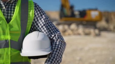 Elinde miğfer olan bir mimar. İnşaatçının elindeki beyaz miğfer. Kazıcının yanındaki adam.