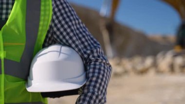 Elinde miğfer olan bir mimar. İnşaatçının elindeki beyaz miğfer. Kazıcının yanındaki adam.