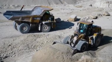 Taş ocağında ağır maden kamyonu ve buldozer var..