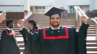 Hintli öğrenci üniversitenin yakınlarında mezuniyeti kutluyor. Eğitim, mezuniyet ve halk konsepti - dış mekan ve şapkalar içinde uluslararası öğrenciler grubu