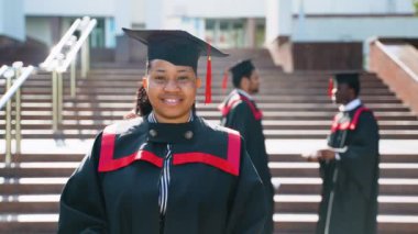 Üniversite kampüsündeki mezuniyet gününde çok ırklı bir arkadaş grubuyla birlikte Afrika kökenli Amerikalı bir kız öğrenci. Eğitim, mezuniyet ve halk konsepti - bir grup uluslararası öğrenci