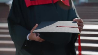 Elinde kırmızı püskül ve diploması olan siyah şapkalı bir mezun. Eğitim, mezuniyet ve halk konsepti - Manto ve şapka giymiş Hintli Asyalı öğrenci