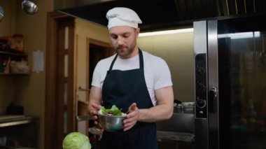 Şef otel mutfağında taze vegan salatası hazırlıyor. Yemek pişirme, meslek ve insan konsepti. Otel mutfağında profesyonel aşçı.
