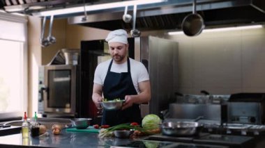 Şef aşçı taze salata hazırlıyor. Yemek pişirme, meslek ve insan konsepti. Otel mutfağında profesyonel aşçı.