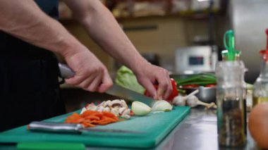 Şef otel mutfağında sebze doğruyor, kapat. Yemek pişirme, meslek ve insan konsepti. Otel mutfağında profesyonel aşçı.