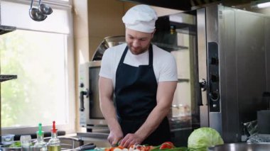 Şef sebze doğruyor ve vegan salatası hazırlıyor. Yemek pişirme, meslek ve insan konsepti. Otel mutfağında profesyonel aşçı.