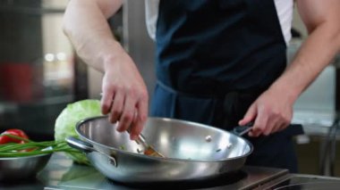 Mutfakta tavada sebze doğrayan şef, kapat. Yemek pişirme, meslek ve insan konsepti. Otel mutfağında profesyonel aşçı.