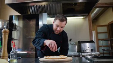 Şef İtalyan pizzası pişiriyor. Masada pizza yapma süreci. Lokanta mutfağında profesyonel aşçı.