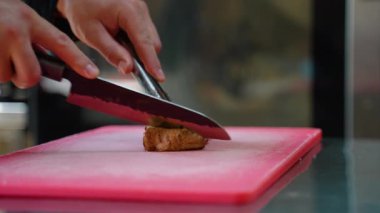 Izgara eti küçük parçalara ayır. Lokanta mutfağında profesyonel aşçı.