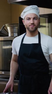 Aşçı adam restoran mutfağında duruyor. Yemek pişirme, meslek ve insan konsepti. Otel mutfağında profesyonel aşçı.