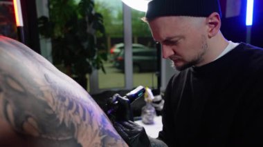 Dövme sanatçısı, kuaförde müşterisinin sırtına dövme yaptırır. Sırtındaki dövme. Sanat konsepti