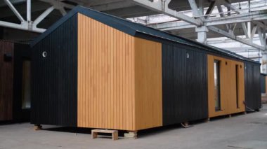 İnşaat alanındaki prefabrik seyyar ahşap ev. Yeni yapılmış tek katlı prefabrik modüler bina. Ekolojik ahşap konut kavramı. Modüler evler fabrikası