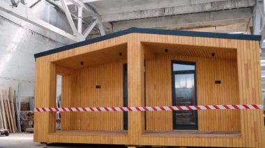 İnşaat alanındaki prefabrik seyyar ahşap ev. Yeni yapılmış tek katlı prefabrik modüler bina. Ekolojik ahşap konut kavramı. Modüler evler fabrikası