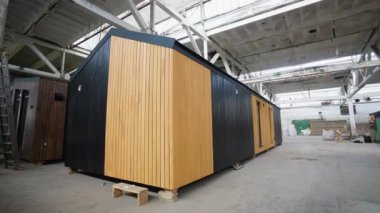 İnşaat alanındaki prefabrik seyyar ahşap ev. Yeni yapılmış tek katlı prefabrik modüler bina. Ekolojik ahşap konut kavramı. Modüler evler fabrikası