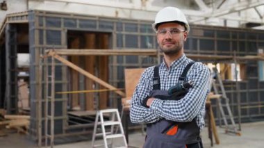 Prefabrik ahşap evin yanında üniformalı bir işçinin portresi. Fabrikadaki modern modüler ev yapımı.