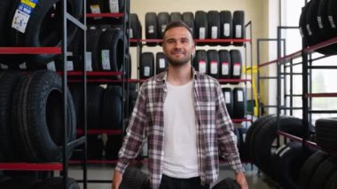 Lastik dükkanında iki yeni lastikle yürüyen bir müşteri. Mevsim için lastik seçme kavramı