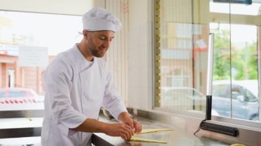 Baker Hamuru Rolls Royce 'a yuvarlanıyor, Pişirme Süreci Kruvasan yapıyor. Fırının konsepti. Fırın yapımı taze pişmiş yiyecekler. Baker pastanede kruvasan yapıyor.