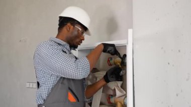 Afrikalı tesisatçı ofise yangın musluğu kuruyor veya denetliyor.