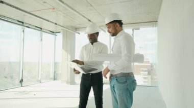 Hintli mimar ve Afrikalı yönetici inşaat alanında buluşuyorlar. Çok ırklı işçi ve mühendis plan üzerinde tartışıyorlar. Yeni bir binayı ziyaret ederken birlikte çalışan iki inşaat işçisi.