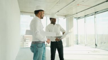 Hintli mimar ve Afrikalı yönetici inşaat alanında buluşuyorlar. Çok ırklı işçi ve mühendis plan üzerinde tartışıyorlar. Yeni bir binayı ziyaret ederken birlikte çalışan iki inşaat işçisi.
