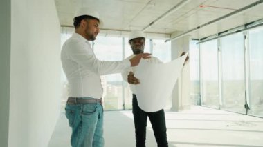 Hintli mimar ve Afrikalı yönetici inşaat alanında buluşuyorlar. Çok ırklı işçi ve mühendis plan üzerinde tartışıyorlar. Yeni bir binayı ziyaret ederken birlikte çalışan iki inşaat işçisi.