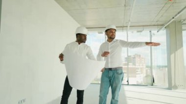 Hintli mimar ve Afrikalı yönetici inşaat alanında buluşuyorlar. Çok ırklı işçi ve mühendis plan üzerinde tartışıyorlar. Yeni bir binayı ziyaret ederken birlikte çalışan iki inşaat işçisi.