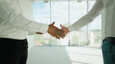 İki çok ırklı inşaatçı inşaat alanında el sıkışıyor. Partnerin tokalaşması. Yeni bir binayı ziyaret ederken birlikte çalışan iki inşaat işçisi.