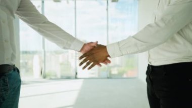 İki çok ırklı inşaatçı inşaat alanında el sıkışıyor. Partnerin tokalaşması. Yeni bir binayı ziyaret ederken birlikte çalışan iki inşaat işçisi.