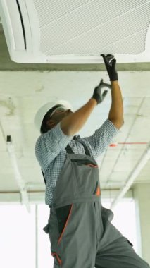 Afrikalı teknisyen evdeki ya da ofisteki klimayı kontrol ediyor. Temiz hava ve oda kliması kavramı