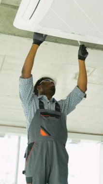 Afrikalı teknisyen evdeki ya da ofisteki klimayı kontrol ediyor. Temiz hava ve oda kliması kavramı