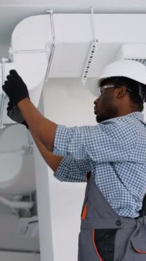 Afrika kökenli Amerikalı işçiler havalandırma ve havalandırma için boru sistemi kuruyor. HVC teknisyeni iş başında. Havalandırma, ısıtma sistemi bakım ve onarım
