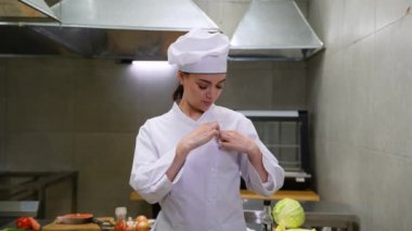 Restoran mutfağında yemek hazırlamadan önce profesyonel kadın aşçı. Yemek pişirme konsepti