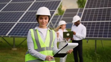 Güneş enerjisi istasyonunda koruyucu miğferli genç kadın mühendisin portresi. Ekoloji yeşil enerji kavramı