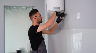 Mühendis eve bir doğal gaz kazanı kuruyor ve boruları kontrol ediyor. Isıtma servisi bakım konsepti. Gaz kazanının tamiri