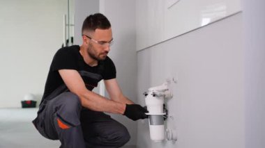 Tamirci eve ya da ofise su filtresi koyuyor. Ters osmoz su arıtma sisteminin kurulumu