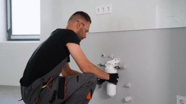 Tamirci eve ya da ofise su filtresi koyuyor. Ters osmoz su arıtma sisteminin kurulumu