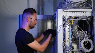 Uzmanlık alanı, sunucu odasındaki internet cihazları ve kablolar üzerinde çalışıyor. Bilgi işlem mühendisi sunucu odasında internet ağı kuruyor