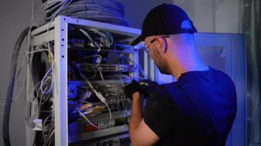 Veri ağıyla çalışırken sunucuyu kuruyor. Bilgi işlem mühendisi sunucu odasında internet ağı kuruyor