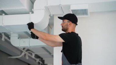 HVC işçisi havalandırma ve havalandırma için boru sistemi kuruyor. HVC teknisyeni iş başında. Havalandırma, ısıtma sistemi bakım ve onarım