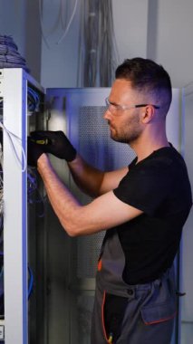 Uzmanlık alanı, sunucu odasındaki internet cihazları ve kablolar üzerinde çalışıyor. Bilgi işlem mühendisi sunucu odasında internet ağı kuruyor