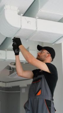 HVC işçisi havalandırma ve havalandırma için boru sistemi kuruyor. HVC teknisyeni iş başında. Havalandırma, ısıtma sistemi bakım ve onarım