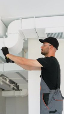 HVC işçisi havalandırma ve havalandırma için boru sistemi kuruyor. HVC teknisyeni iş başında. Havalandırma, ısıtma sistemi bakım ve onarım