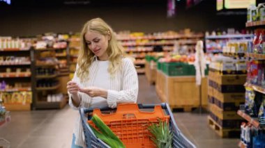 Kadın ev hanımı, market fiyatlarındaki artış ve enflasyondaki kağıt kontrolünden şok olmuş gibi görünüyor. İnsanlar alışveriş konsepti