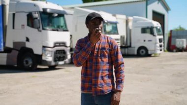 Kamyon şoförü kamyon parkında telsiz kullanıyor. Nakliye ve ulaşım kavramı. Kamyoncu yaşam tarzı